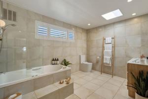 a large bathroom with a tub and a toilet at Bunkers at Seven Mile in Seven Mile Beach +74 photos