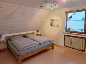a bedroom with a bed in a room with a window at Gemütliches Ferienhaus in Schnaid mit zwei separaten und geräumigen Wohnungen - ausgestattet mit je einer großen Küche, zwei Schlafzimmern und einem Badezimmer in Hallerndorf