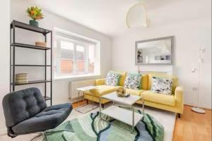 a living room with a yellow couch and a table at Spacious 4-Bed Home with Workspace in Coundon