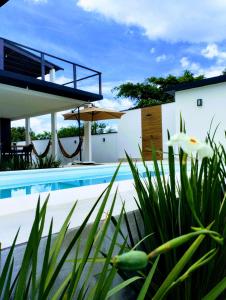 a villa with a swimming pool and a house at Casa Telhado Inclinado in Saquarema