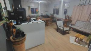 a living room with a counter and chairs and a table at Pousada Cactos in Chapada dos Guimarães