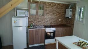 a kitchen with a white refrigerator and a stove at Cabañas Felipe in Pichilemu +18 photos