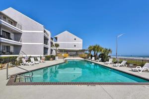 a swimming pool in front of a building at Ocean-View Balcony: Family Gem on Seawall Blvd! in Galveston