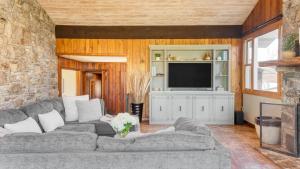 a living room with a couch and a television at Asher by AvantStay in Asheville