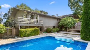 a house with a swimming pool in front of a house at Asher by AvantStay in Asheville