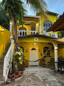 a yellow house with a palm tree in front of it at Hermosa Casa Familiar en Suchitoto in Aguacayo