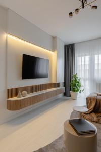 a living room with a tv on a wall at The Signature by D'or Selection in Bucharest