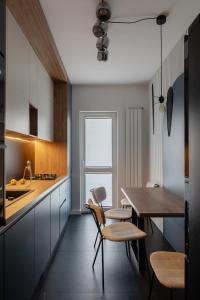 a kitchen with a table and chairs and a dining room at The Signature by D'or Selection in Bucharest
