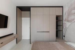 a bedroom with white cabinets and a tv at The Signature by D'or Selection in Bucharest