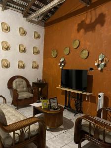 a living room with a flat screen tv on a wall at Hermosa Casa Familiar en Suchitoto in Aguacayo