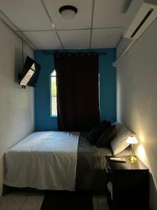 a bedroom with a bed and a blue wall at Hermosa Casa Familiar en Suchitoto in Aguacayo
