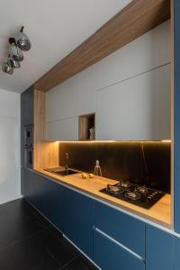 a kitchen with blue cabinets and a counter top at The Signature by D'or Selection in Bucharest +9 photos