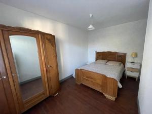 a bedroom with a wooden bed and a dresser at Gîte centre coulon - Le Héron in Coulon