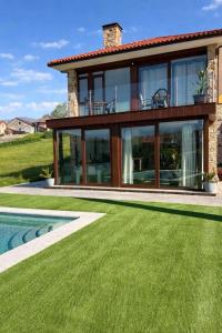 a house with a pool and a yard at CESANTES VILLAGE e in Pontevedra
