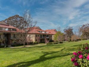 a house with a yard with grass and flowers at Leisure Inn Spires in Leura
