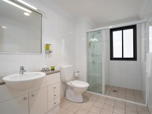 a bathroom with a toilet and a sink and a shower at Leisure Inn Spires in Leura +82 photos
