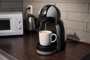 a coffee maker is pouring coffee into a cup at Narvikfjellet Cozy 2BR Apartment in Narvik