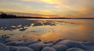 a sunset over a body of water with snow at Lake Simcoe Beach Oasis with Backyard and Firepit in Georgina