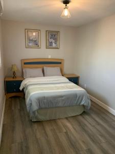 a bedroom with a large bed and a wooden floor at Lake Simcoe Beach Oasis with Backyard and Firepit in Georgina