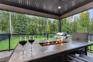 two glasses of wine on a table with a fire pit at Hearthside Estate in Prince George