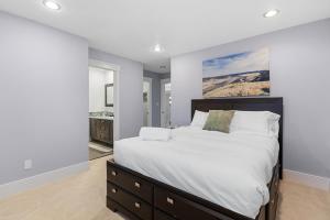 a bedroom with a large bed with white sheets at Hearthside Estate in Prince George