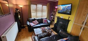 a living room with two leather chairs and a fireplace at An Tuar Ceatha in Castlebar