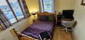 a bedroom with a bed with a purple comforter at An Tuar Ceatha in Castlebar