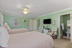 ein Schlafzimmer mit zwei Betten und einem Deckenventilator in der Unterkunft Green Tree Inn in Elsah