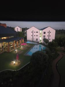 a view of a building with a pool at night at Sir Chase Place in Boksburg