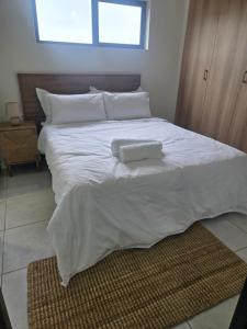 a large white bed with two towels on it at Sir Chase Place in Boksburg +6 photos