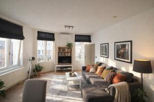 a living room with a couch and a tv at The White Boutique Loft in Antwerp