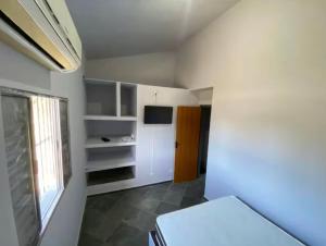 a white room with a kitchen and a window at Seu Refúgio no Guarujá in Guarujá