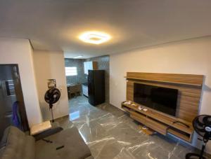 a living room with a television and a fireplace at Seu Refúgio no Guarujá in Guarujá