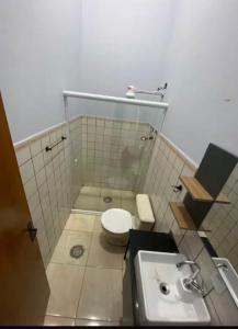 a bathroom with a toilet and a sink at Seu Refúgio no Guarujá in Guarujá