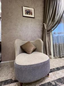 a chair with a pillow sitting in a living room at فيلا دريم in Sphinx International Airport +17 photos