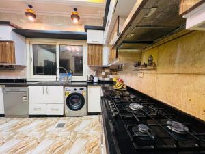 a kitchen with a stove and a washing machine at فيلا دريم in Sphinx International Airport