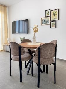 a dining room table with chairs and a tv at Kantara Beach Resort Apartment FeMa in Athalassa