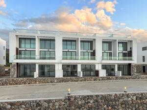 a white building with a lot of windows at Kantara Beach Resort Apartment FeMa in Athalassa