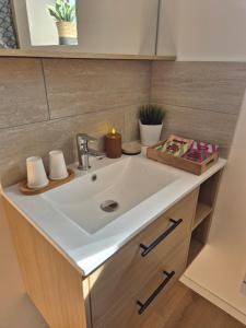 a bathroom with a sink with a candle on it at Gîte de l'Avenue Verte in Neufchâtel-en-Bray +11 photos