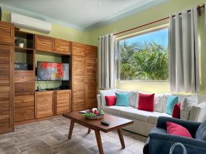 a living room with a couch and a window at Casa Sonoma - Charming Condos Minutes from Beach & Reef in Puerto Morelos