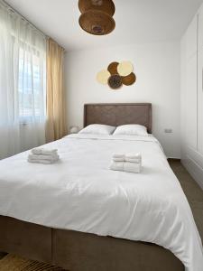 a bedroom with a large white bed with towels on it at Kantara Beach Resort Apartment FeMa in Athalassa +8 photos