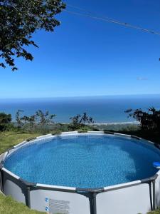 a swimming pool with the ocean in the background at Hostal Mirador Mar Nevado in Buritaca