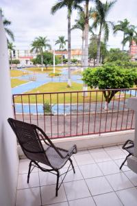 a balcony with two chairs and a view of a pool at Hotel Imperador Caldas Novas - GO - Facil acesso aos parques aquaticos e polo gastronômico noturno in Caldas Novas