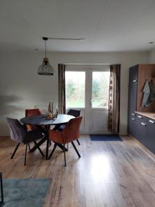 a dining room with a table and chairs at Het Gewei in Burgh Haamstede