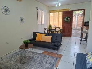 a living room with a black couch and a table at Tulip House in Comayagua