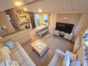 an overhead view of a living room with a couch and a tv at Whitstable Hollington in Seasalter