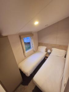 two beds in a small room with a window at Whitstable Hollington in Seasalter