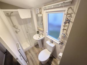 a bathroom with a toilet and a sink and a window at Whitstable Hollington in Seasalter +24 photos