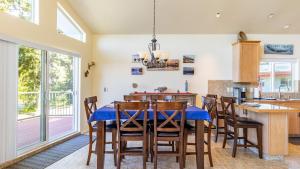 a dining room with a blue table and chairs at Harborview Getaway by AvantStay in Langley