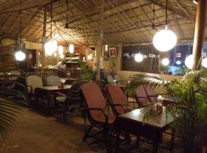 a restaurant with tables and chairs and lights at Namaste Beach Huts in Patnem +73 photos